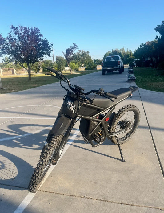 Riding Times GT73 electric bike upgraded version parked on driveway with off-road tires and black frame under clear sky