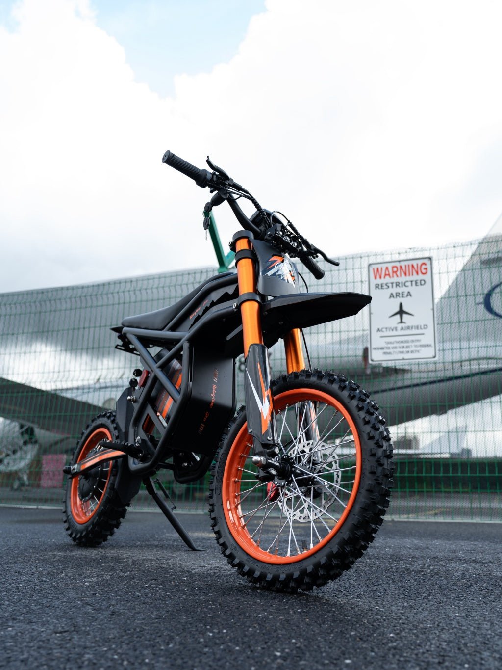 GT54 electric mini motorbike for kids and adults with orange and black design on road