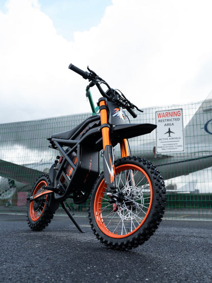 GT54 electric mini motorbike for kids and adults with orange and black design on road