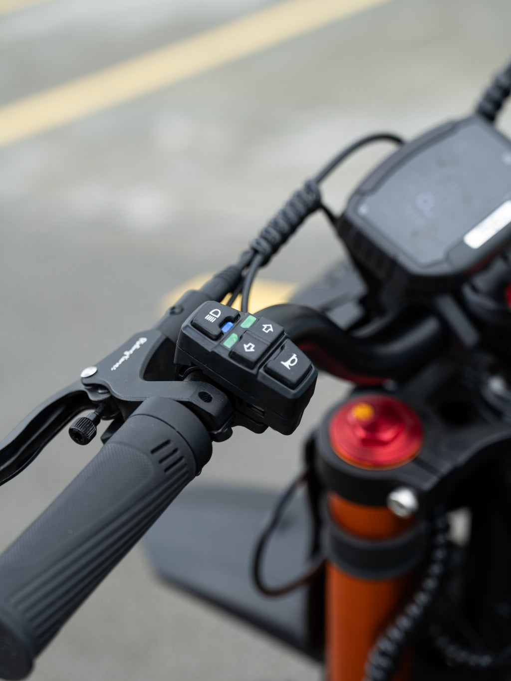 Close-up of GT54 electric mini motorbike handlebar control with power and horn buttons